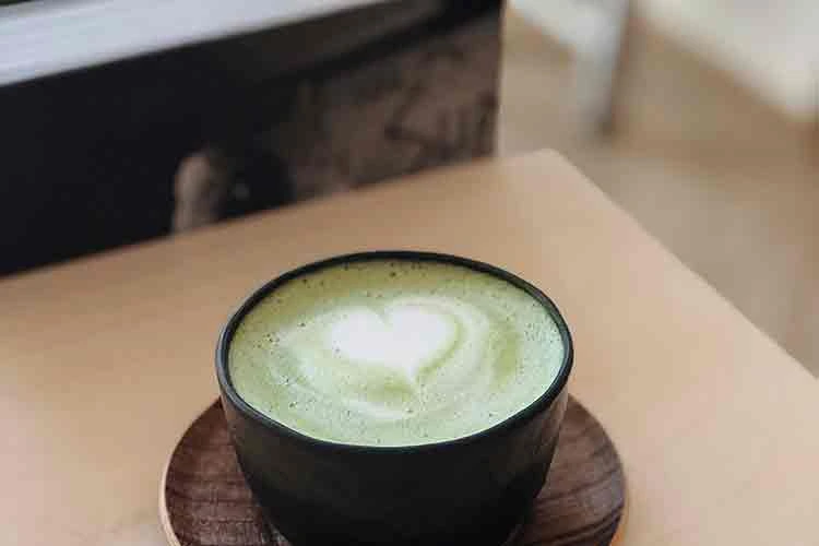 Matcha latte in a black up on a wooden table