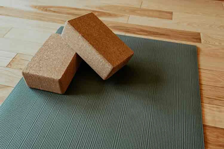 two cork yoga blocks on a green yoga mat