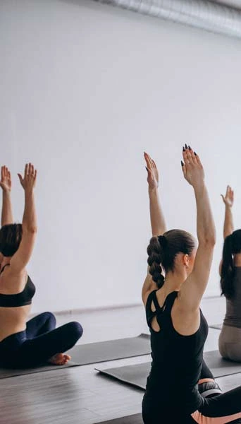 half of a full image of a yoga class in studio sitting on a yoga mat